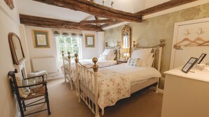 Ein Schlafzimmer mit einem großen Bett, einem Holzstuhl, einem Schminktisch und einem Spiegel.