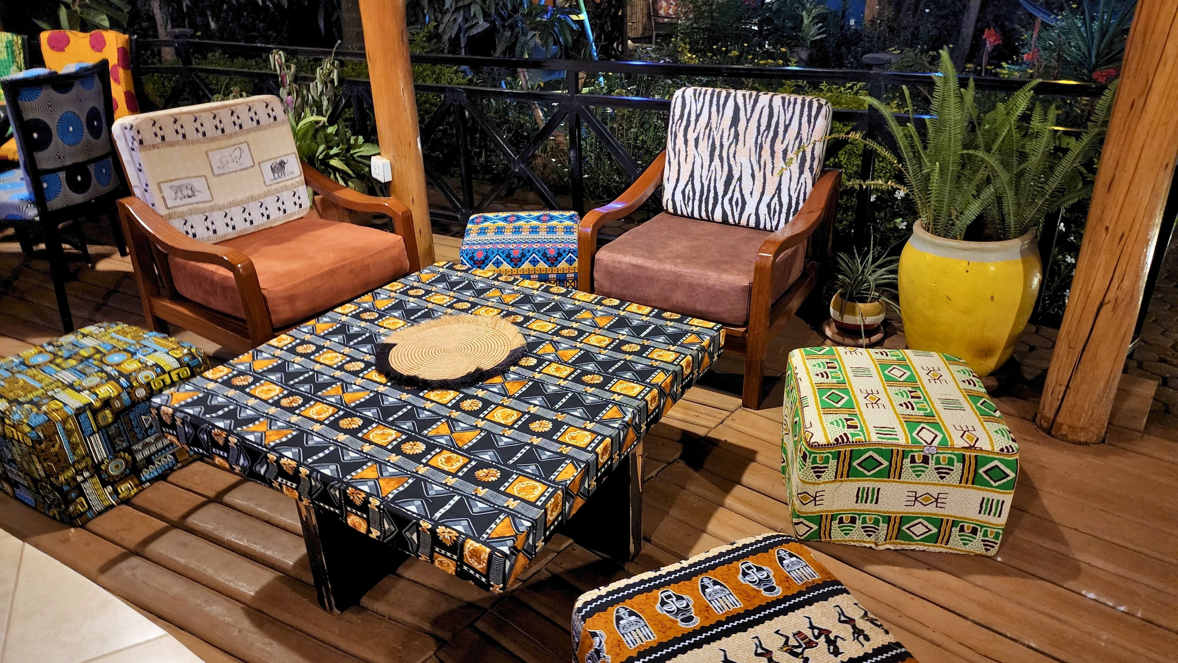 Un área de estar al aire libre con muebles de madera y cojines estampados.