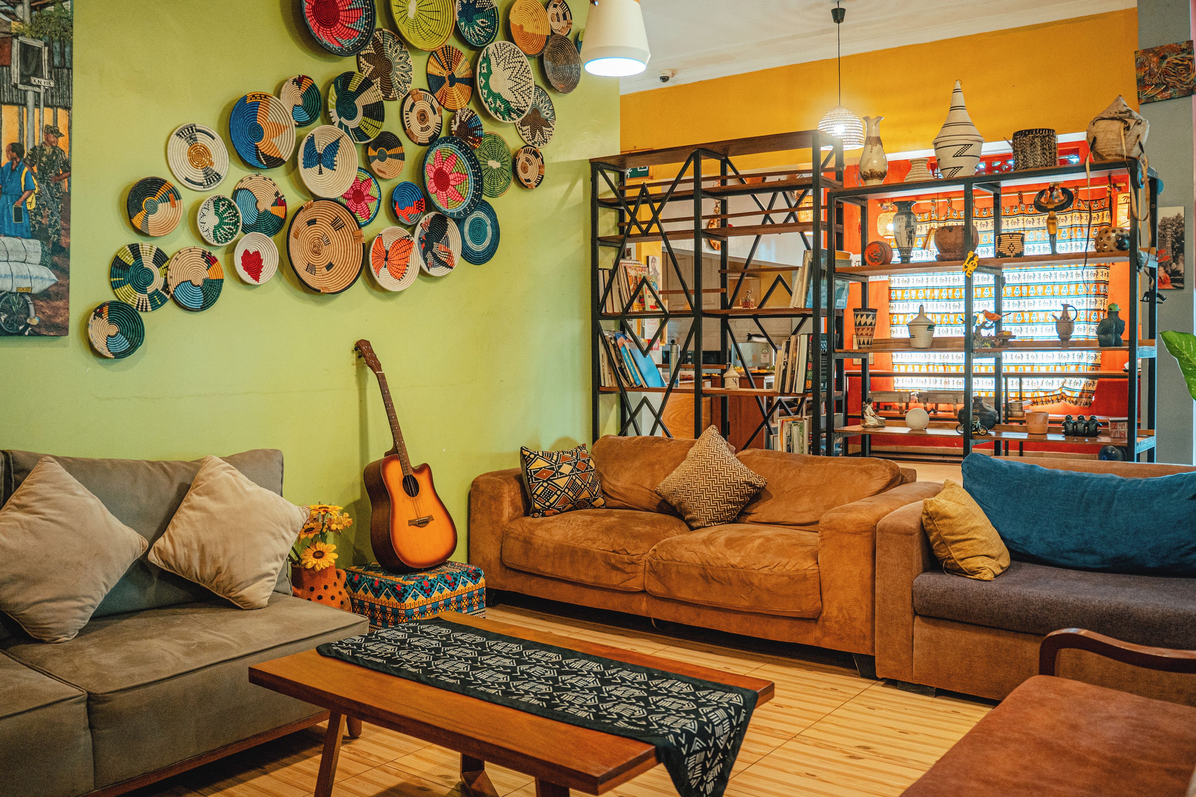 Ein gemütliches Wohnzimmer mit einer braunen Couch, einem Couchtisch und einer Gitarre.