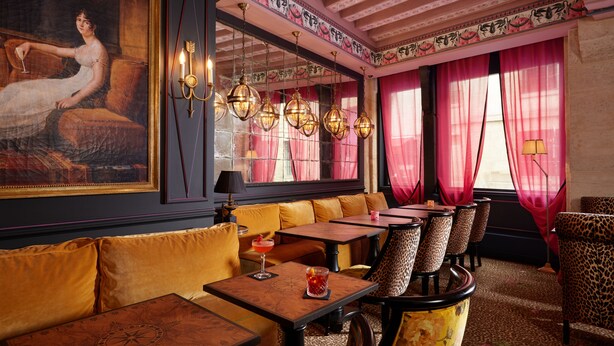 A restaurant with a classic interior, featuring a large painting, patterned ceiling, and traditional furnishings. - Hôtel de JoBo (Paris)