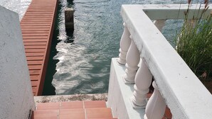 A view of a water body with a wooden deck and a white balustrade. - Villa 410D at Jolly Harbour (Jolly Harbour)