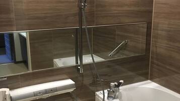 A modern bathroom with a bathtub, a shower, and a vanity with a mirror.