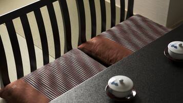 A dining table with a dark surface and two white teapots with blue designs.