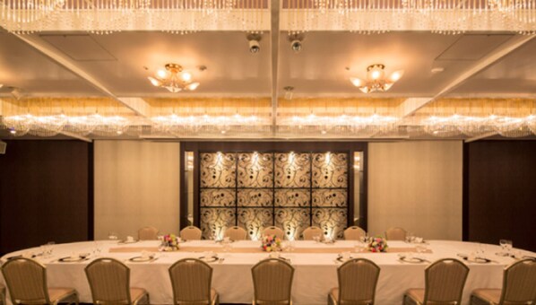 A banquet hall with a long table set for a formal event, surrounded by chairs. - KKR Hotel Kumamoto (Kumamoto)