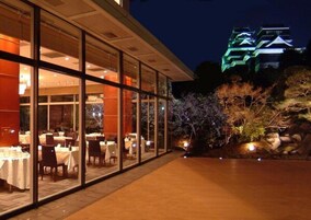 Un restaurante con comedor interior y vista a un edificio tradicional, de noche.
