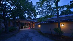Een traditioneel Japans gebouw met een binnentuin, houten balken en een pannendak.