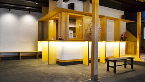 Zona de recepción con un banco, mostrador e indicación de Wi-Fi gratuito.