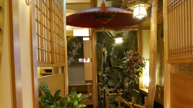 Ein traditioneller japanischer Gang mit Holzbauten, einem Steinweg und einem hängenden Laternenleuchter.