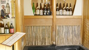 Ein traditionelles japanisches Bad mit hölzernen Bänken und einer Bambuswand.