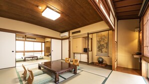 A traditional Japanese room with tatami flooring, a low wooden table, and sliding doors. - Yamadaya Ryokan (Kyoto)