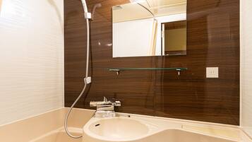 A compact bathroom with a white sink, mirror, and toilet.