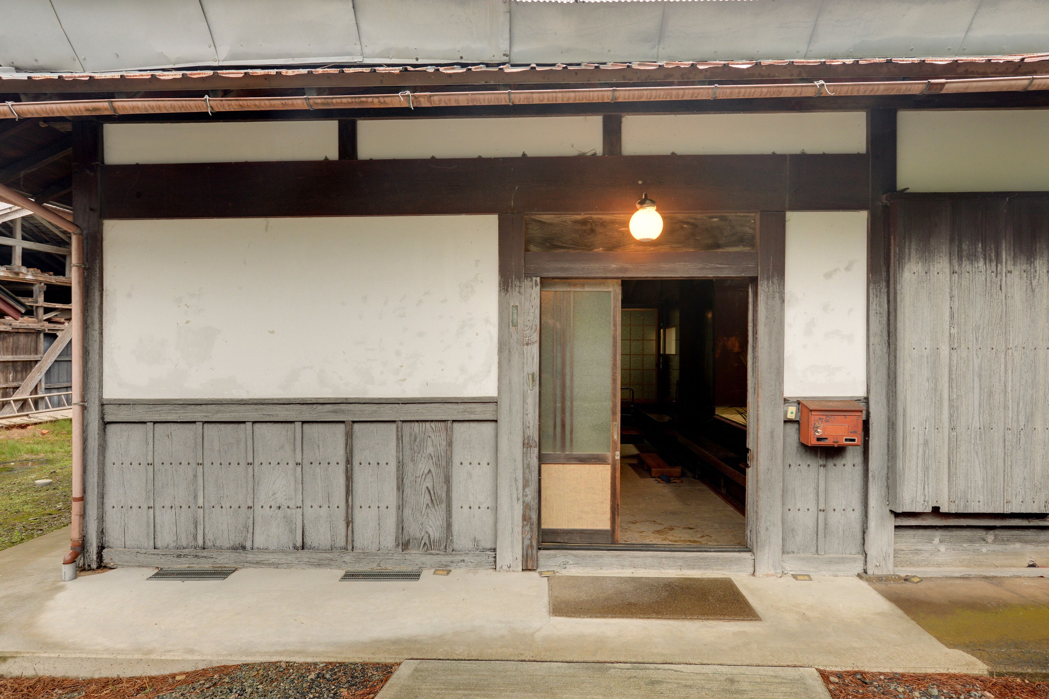 En traditionell japansk byggnad med en träfasad, en tydligt markerad entré och en hängande lampa.