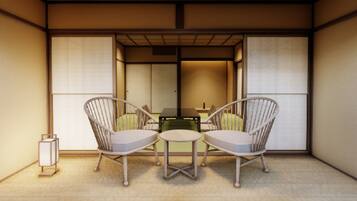 A traditional Japanese room with tatami flooring, two tatami mats, a low table, and two chairs.