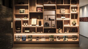 A well-organized display of books and decorative items in a wooden shelving unit, with soft lighting highlighting the contents.