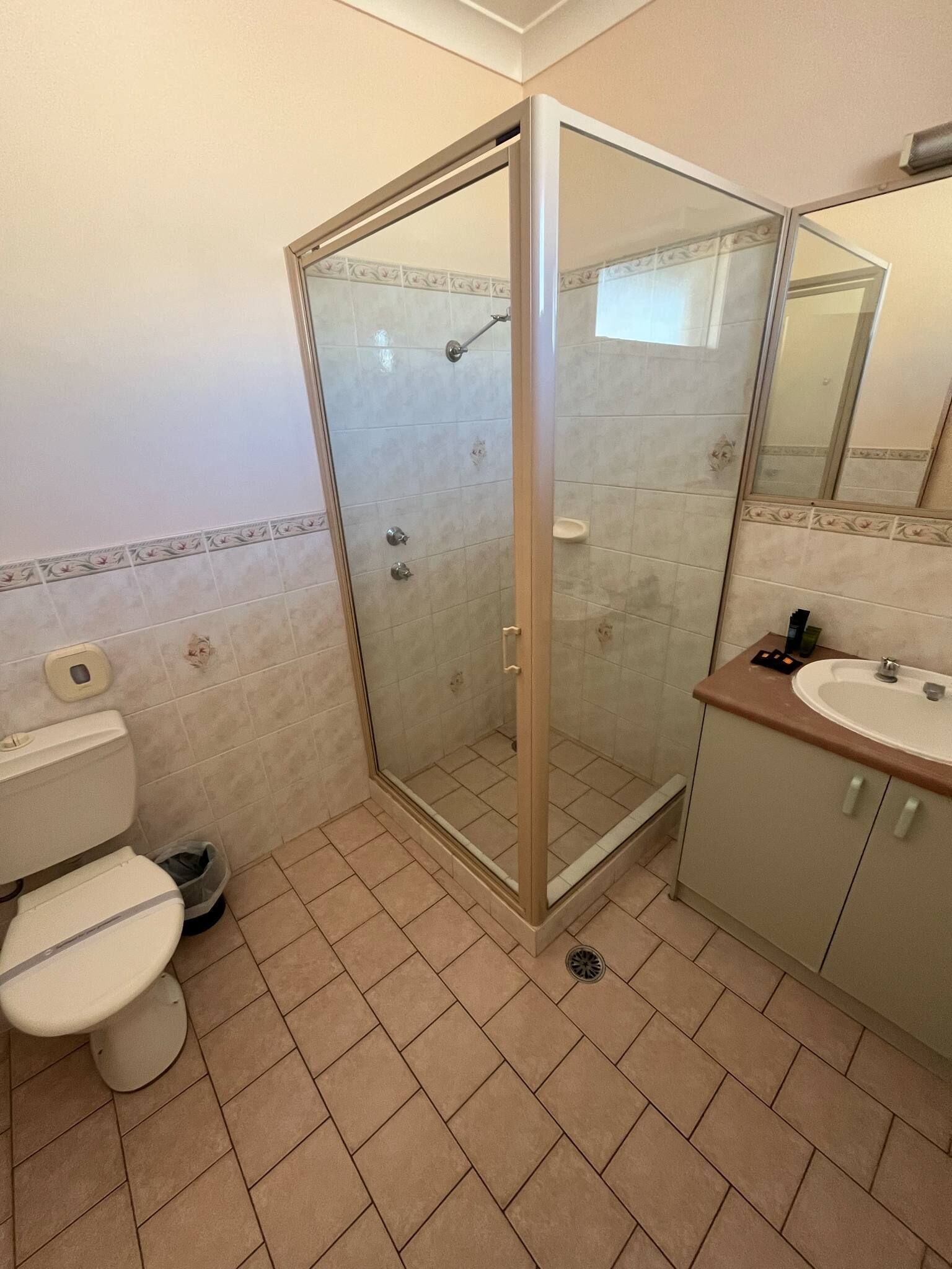 Une salle de bain avec une douche à parois de verre, des toilettes et un lavabo.