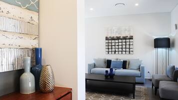 Una sala de estar moderna con sofá, mesa de centro y jarrones decorativos.