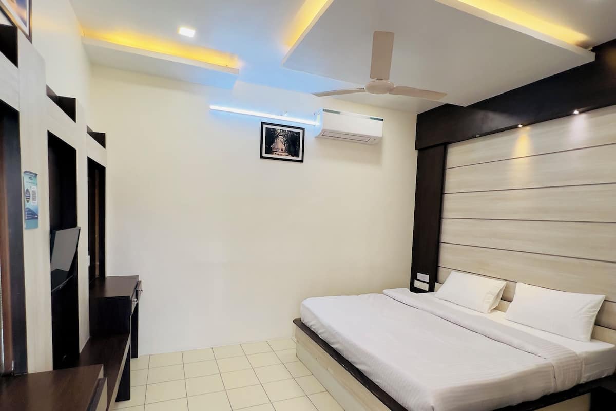 Ein modernes Schlafzimmer mit einem Bett, einem Schreibtisch und einem Deckenventilator.