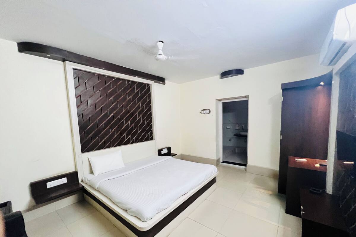 Ein modernes Schlafzimmer mit einem Bett, einem Deckenventilator, einem Kleiderschrank und einer Tür zu einem Badezimmer.