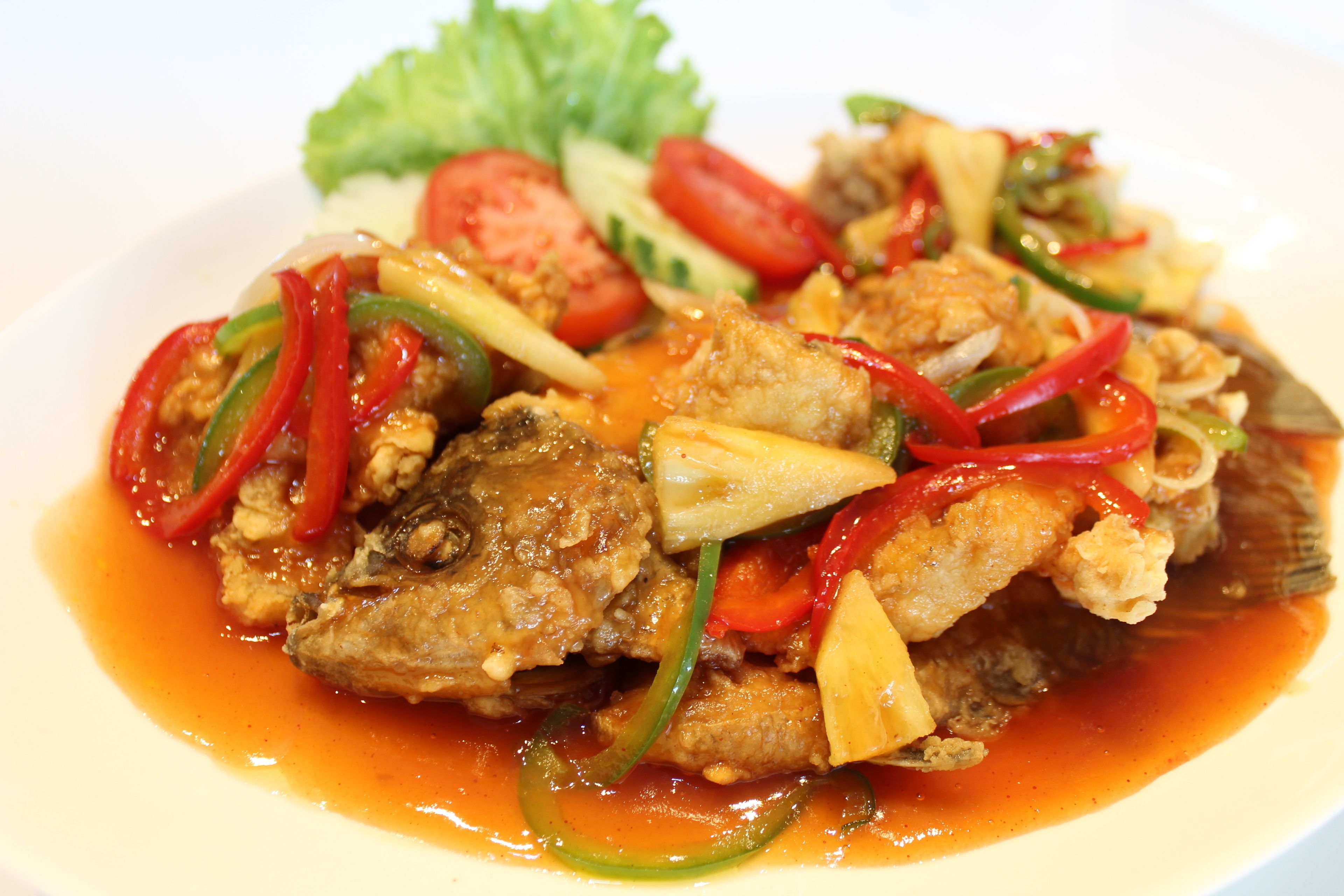 A plate of stir-fried chicken with vegetables and sauce.