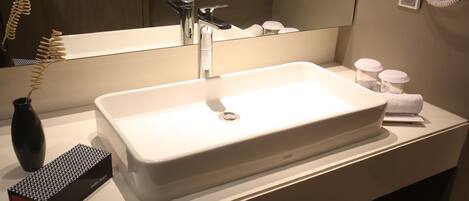 A bathroom with a white sink, a mirror, a towel, and a hairdryer.