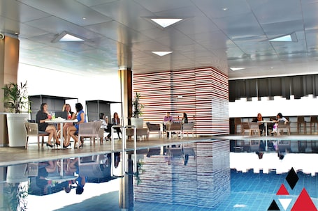 Una piscina techada, sillones reclinables de piscina