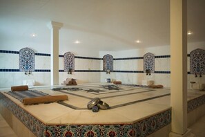 A spa room with a central massage table, decorative tiles, and a patterned floor. - Sandy Beach Hotel - All Inclusive (Manavgat)