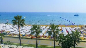 A beach with numerous umbrellas and palm trees. - Sandy Beach Hotel - All Inclusive (Manavgat)