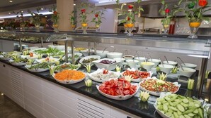 A buffet with various food items and decorative flowers. - Sandy Beach Hotel - All Inclusive (Manavgat)