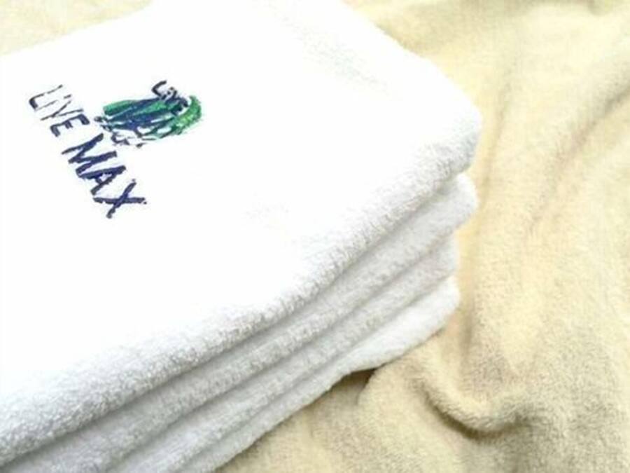 Un montón de toallas blancas, con un logotipo y texto en una de ellas.