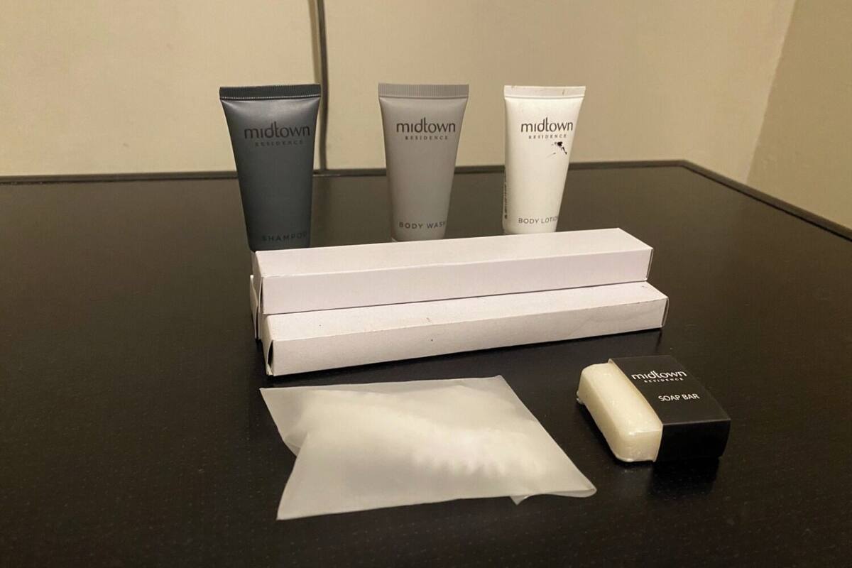 Een tafel met toiletartikelen, waaronder een shampoo, douchegel, bodylotion en zeep.