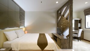 Ein modernes Hotelzimmer mit einem großen Bett, einem Schreibtisch und einem Sessel.