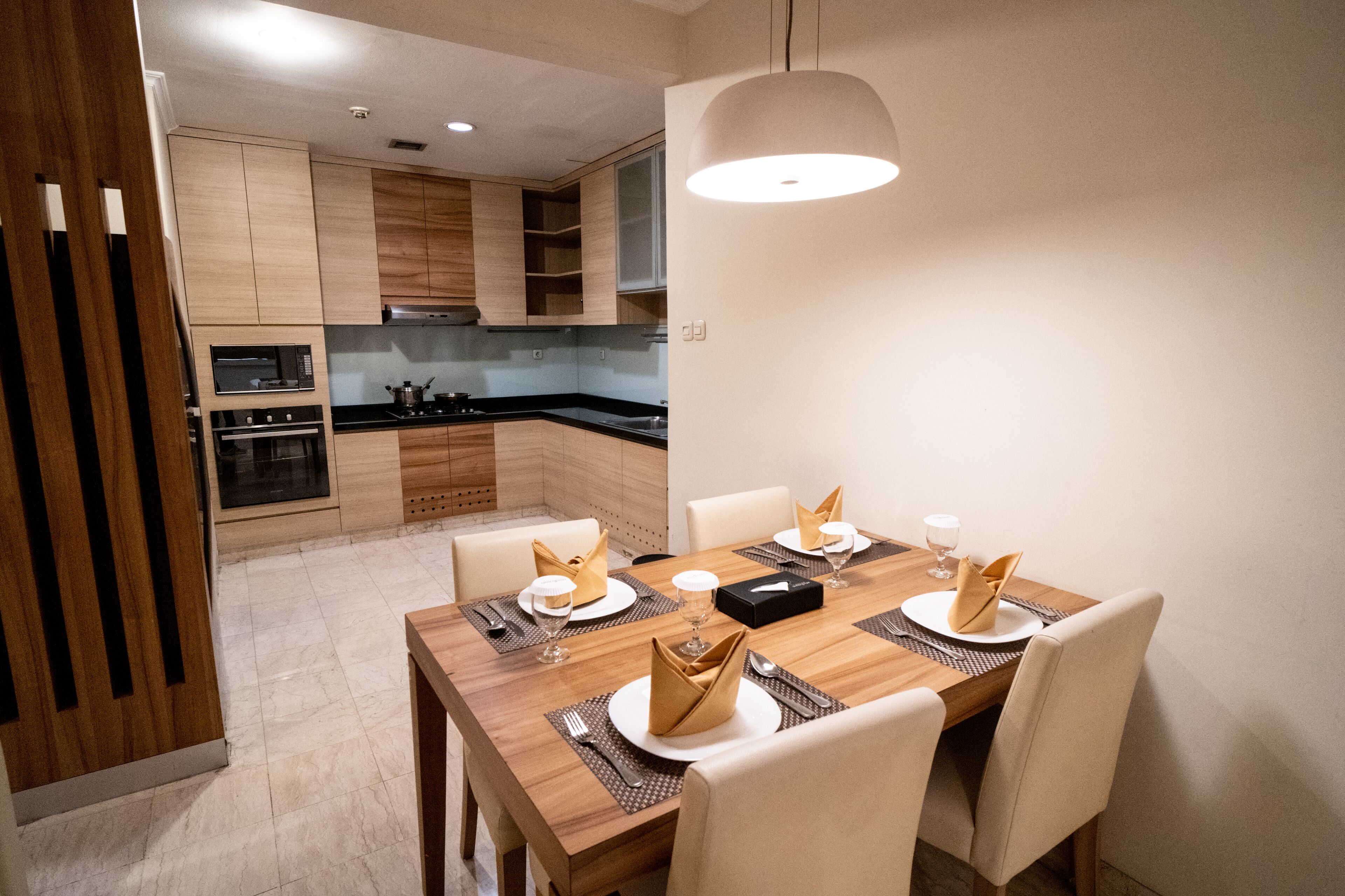 A modern kitchen with wooden cabinets and a dining area set for six.