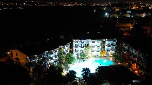 A hotel with a swimming pool, multiple floors, and a well-lit exterior. - Lemas Suite Hotel  (Manavgat)