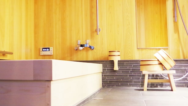 Un baño moderno con pared de madera, una bañera grande, un lavamanos y un espejo.