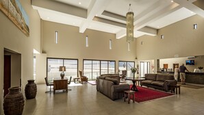 A spacious lobby with a high ceiling, large windows, and a reception desk. - Springbok Inn by Country Hotels (Nama Khoi)
