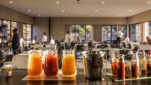 A hotel dining area with multiple tables, a buffet setup, and a view of the outdoors. - Springbok Inn by Country Hotels (Nama Khoi)