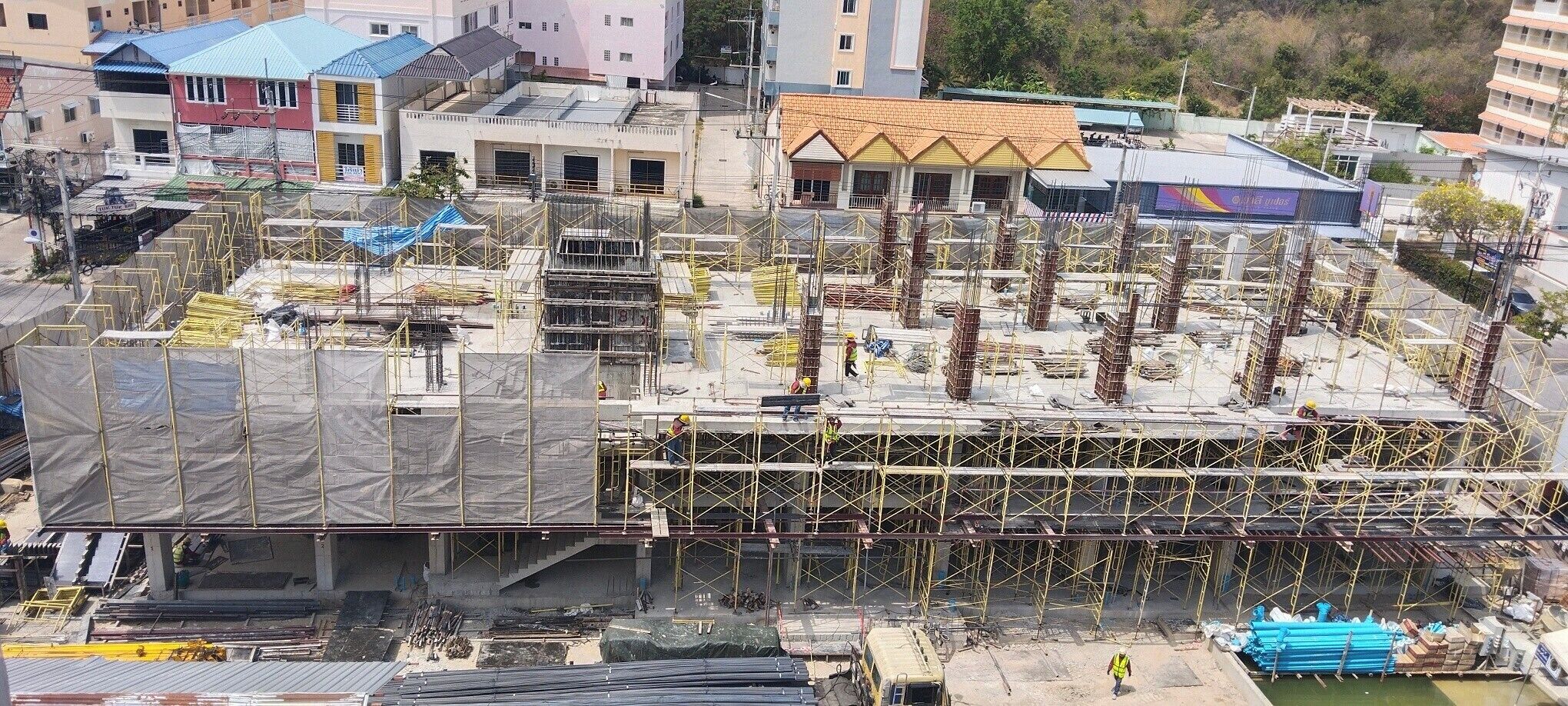 A multi-story building under construction with visible scaffolding and construction materials.