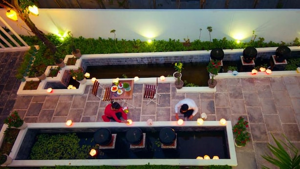 A rooftop terrace with a dining area, seating, and a small water feature. - Minh Phat Homestay (Da Nang)