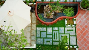 A garden with a maze, a pond, and a white umbrella. - Minh Phat Homestay (Da Nang)