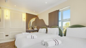 A hotel room with two beds, a large window, and a wall-mounted mirror. - London Star Hotel (London)