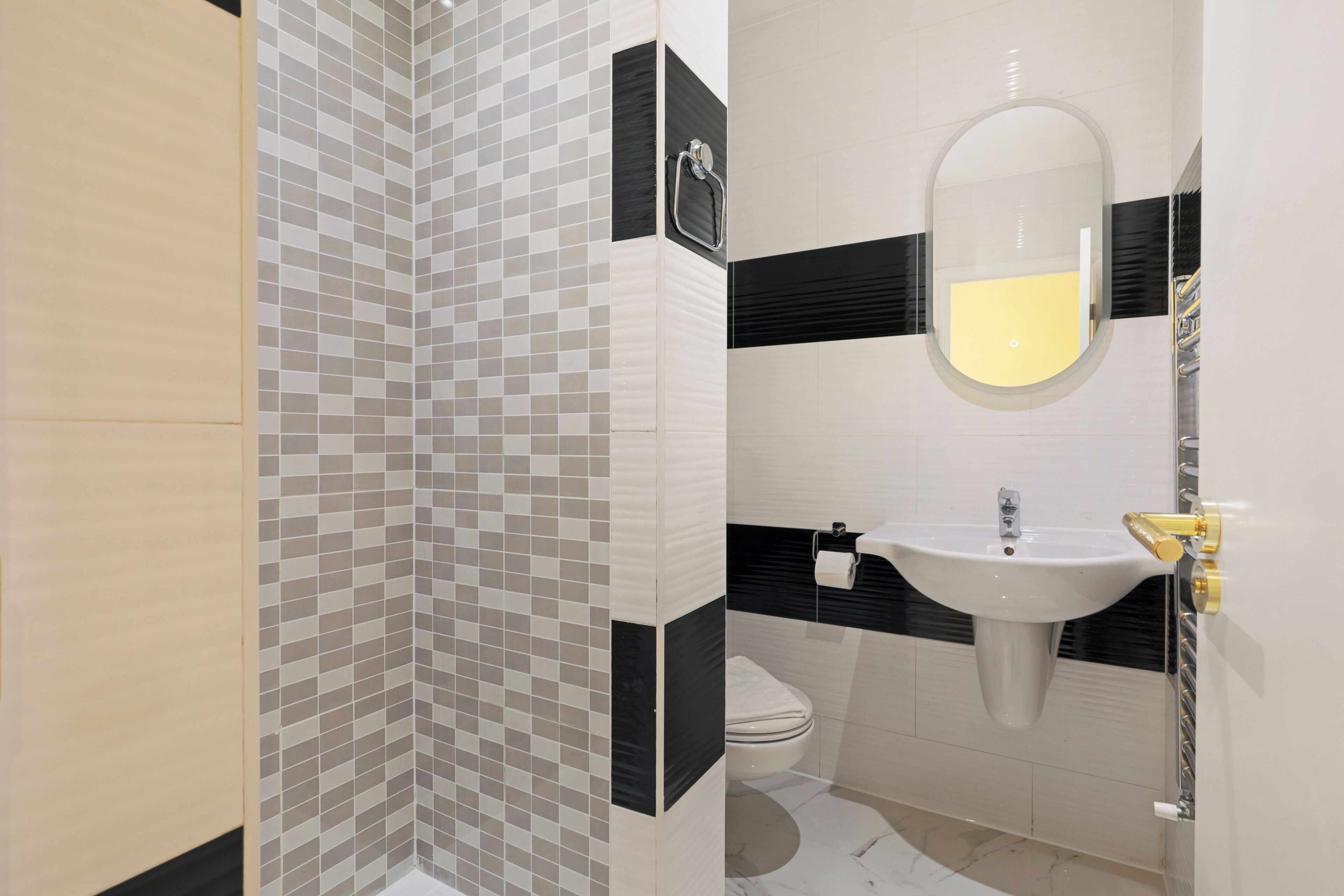 Un baño con ducha revestida de azulejos, lavabo con espejo y retrete.