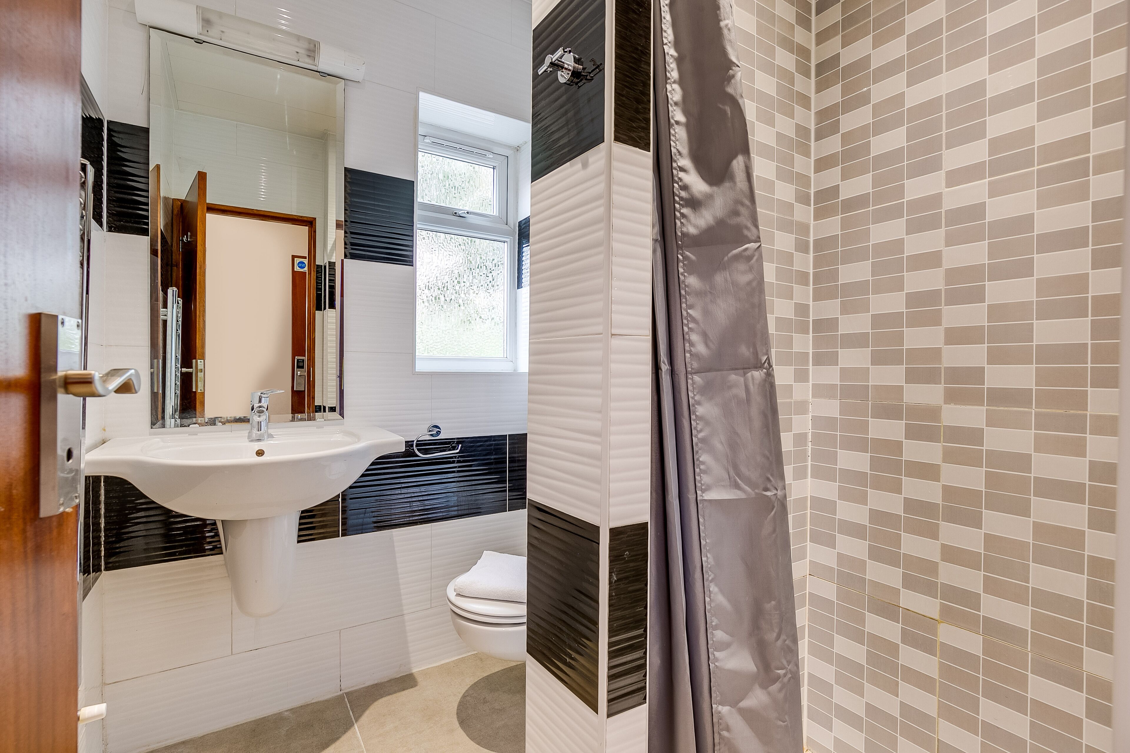 A bathroom with a sink, mirror, and toilet.