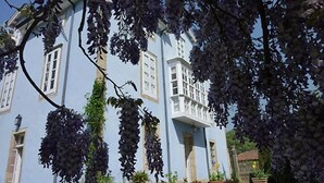 A light blue building with multiple windows and a balcony. - La Casona Azul (Corvera de Toranzo)