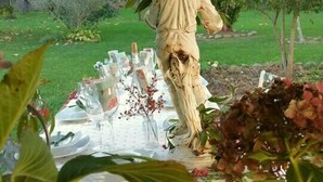 A statue in a garden with a table set for a meal. - La Casona Azul (Corvera de Toranzo)