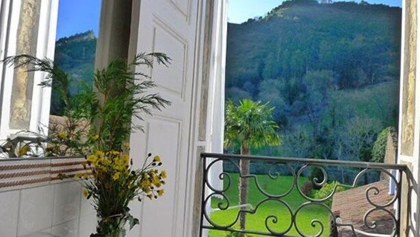 A bathroom with a large window, a white bathtub, and a decorative plant. - La Casona Azul (Corvera de Toranzo)