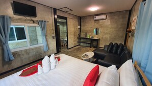 A hotel room with a bed, a small table, a sofa, a desk, and a mirror. - Banphu Montalang Resort (Mae Hong Son)