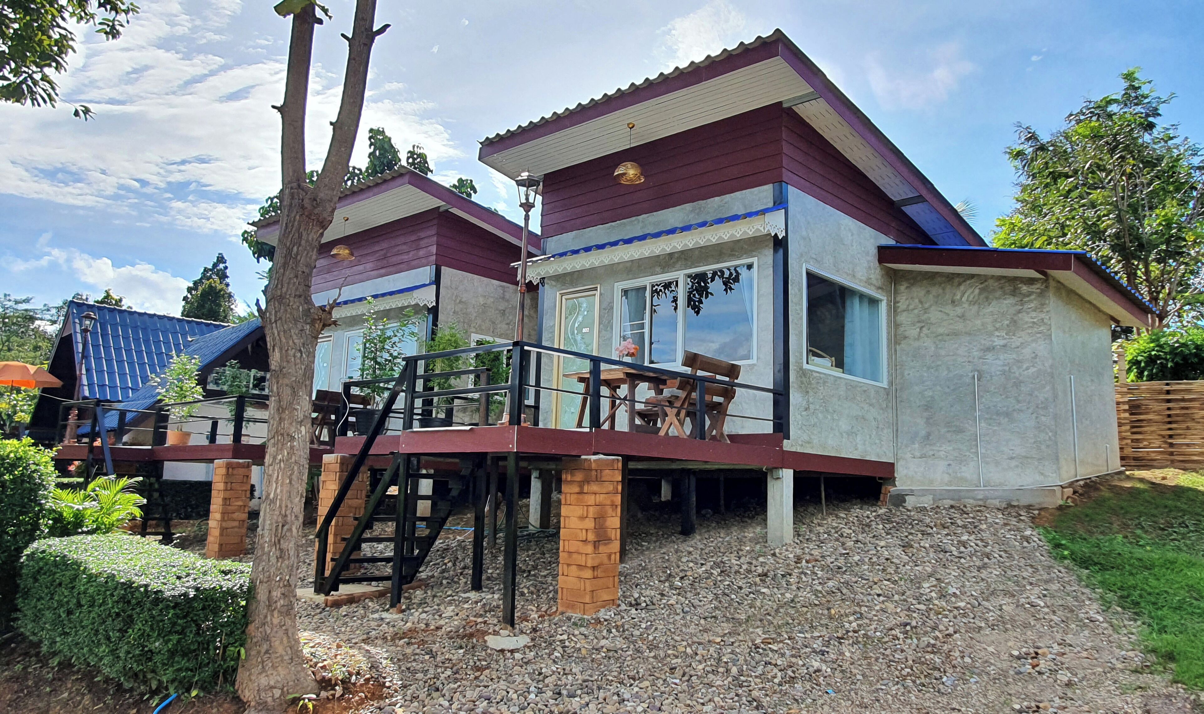 A two-story building with a balcony and a staircase leading to the upper floor.