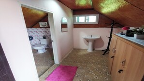 A small bathroom with a toilet, sink, and wooden cabinet. - Banphu Montalang Resort (Mae Hong Son)