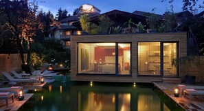 Une maison moderne dotée d’une piscine, d’une terrasse en bois et d’un espace salon extérieur.