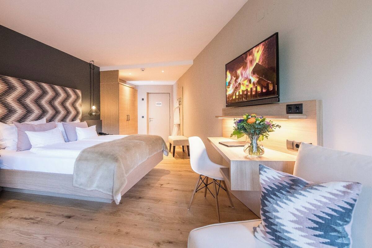 Una habitación de hotel moderna con una cama, un escritorio y una silla.